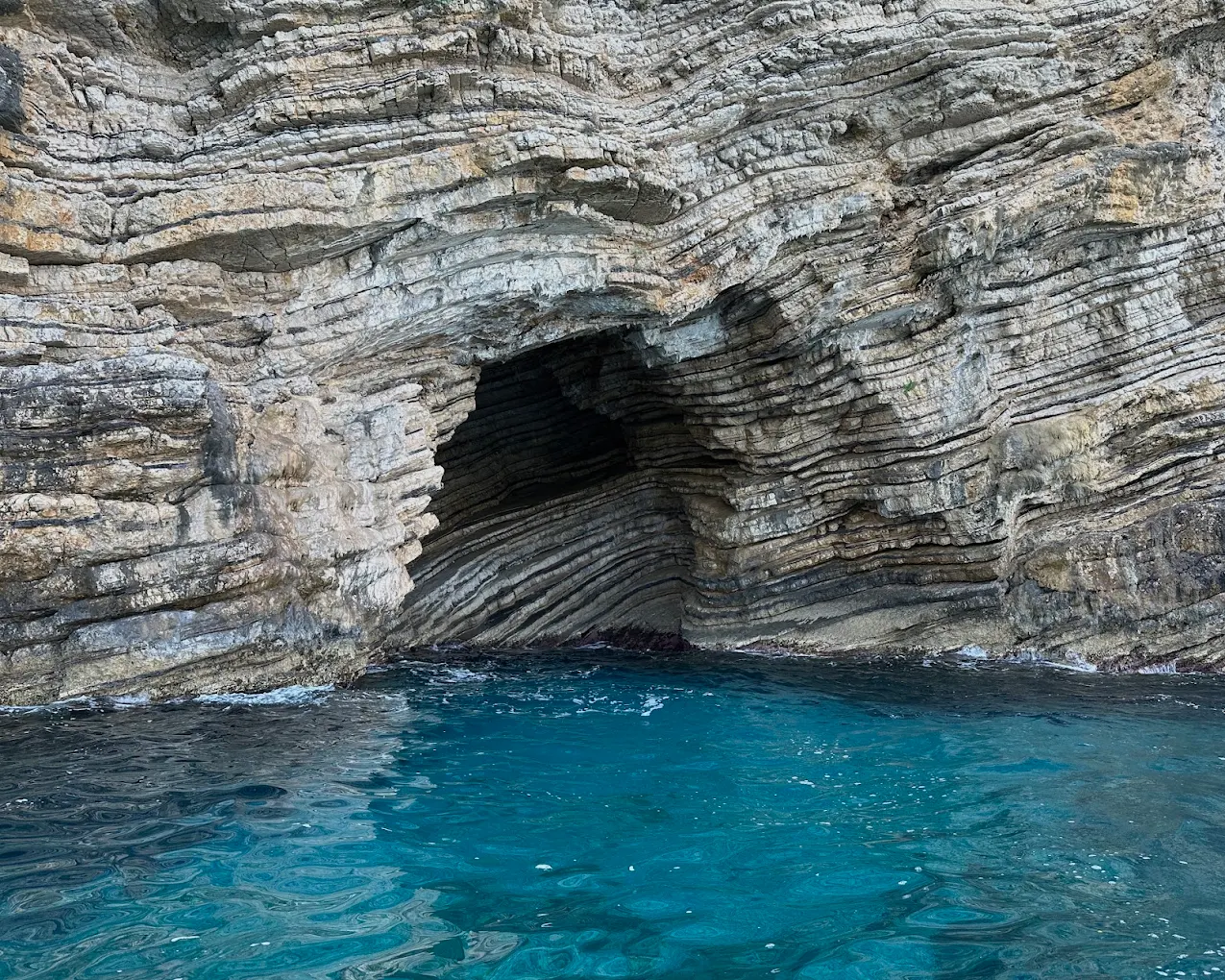 A sea cave opening in the cliffs along the Paleokastritsa coast.